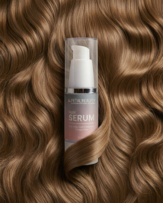 Hair serum bottle with wavy brown hair in the background
